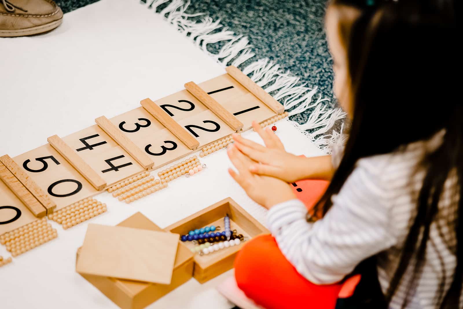 children's house student with montessori math work