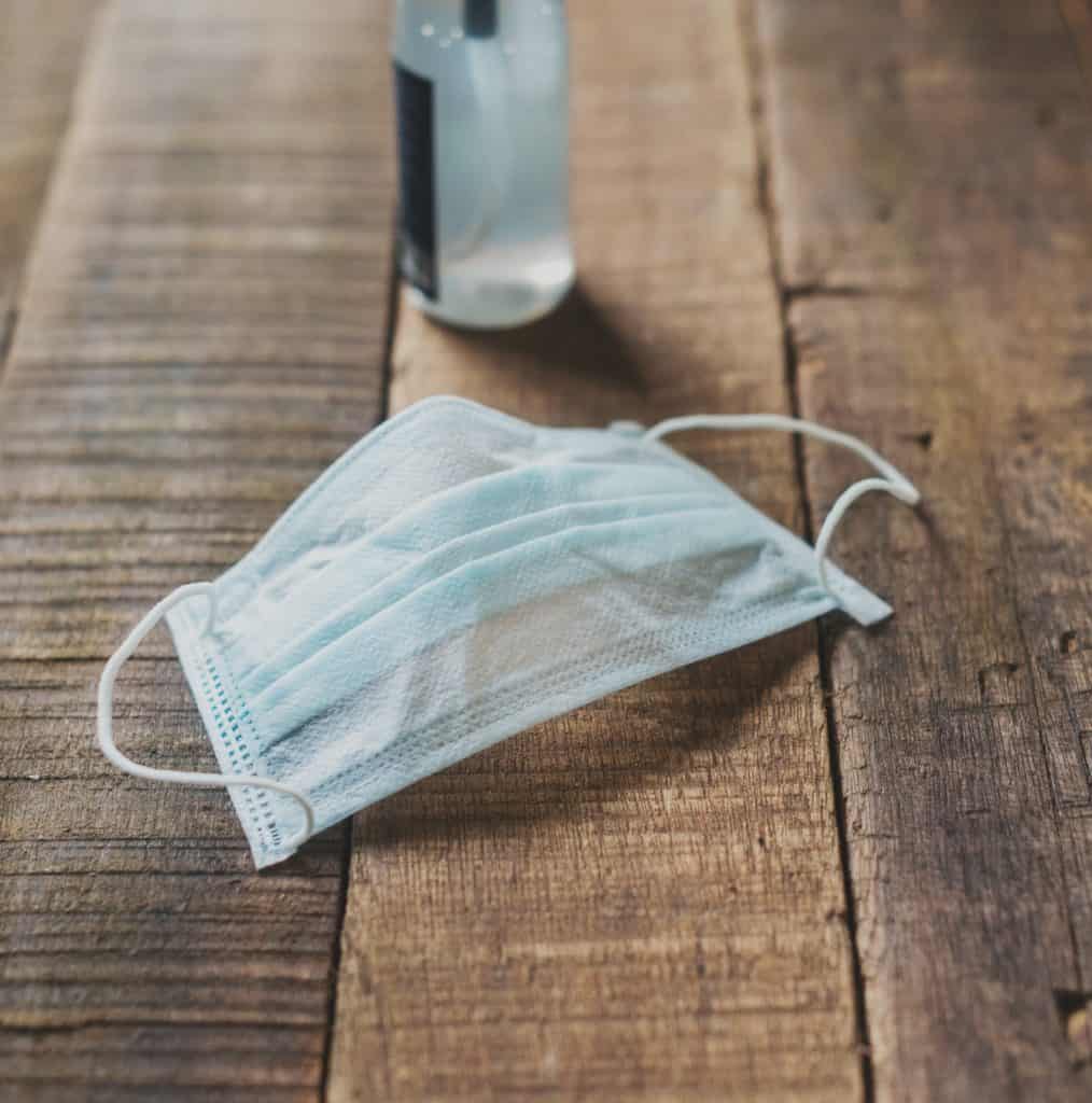 mask and sanitizer on a wooden table