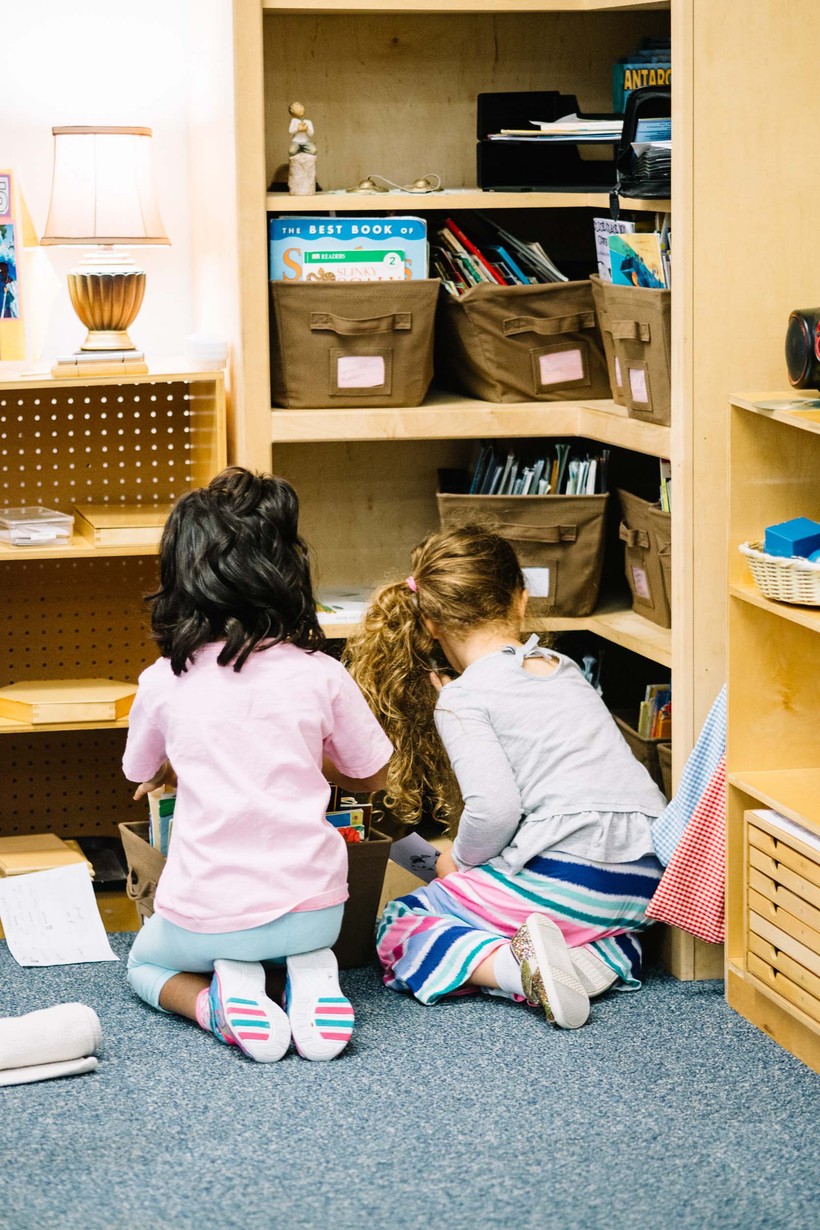 Two young students going through a shelf.