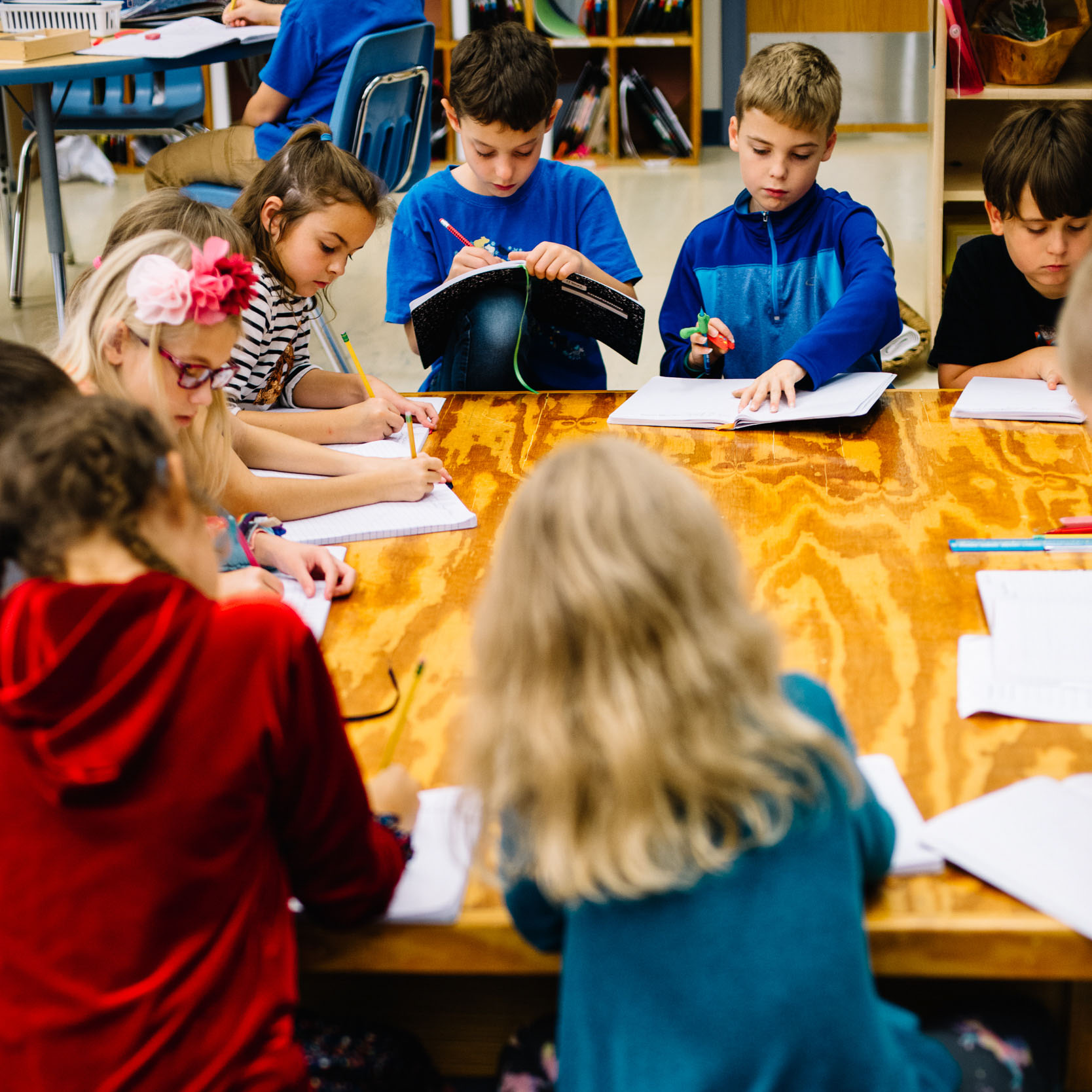 A group of young students writing in their notebooks.